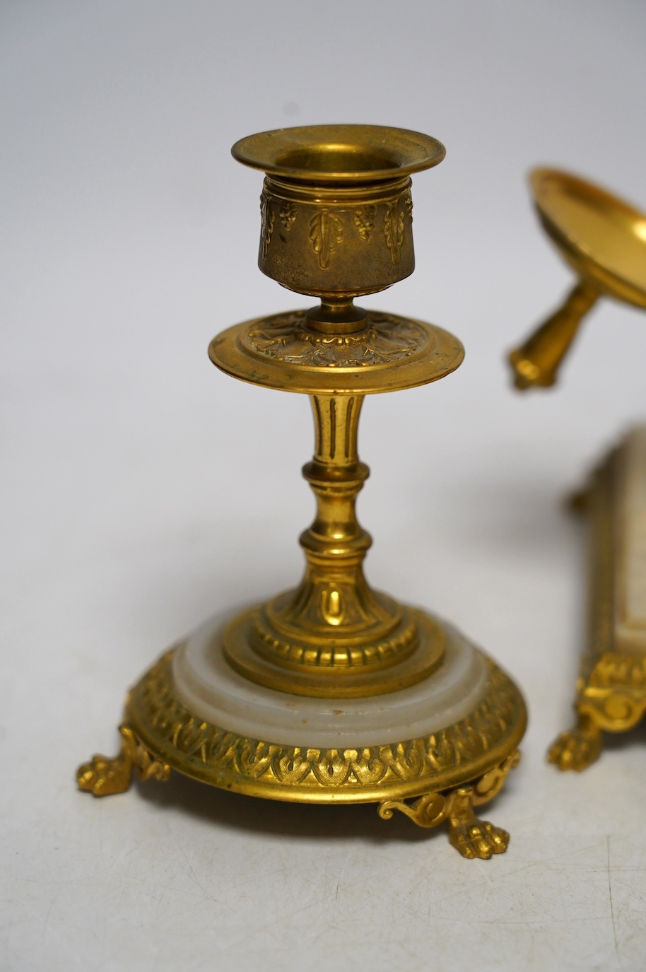 An early 20th century onyx and gilt metal desk set comprising inkwell and a pair of candlesticks, 13.5cm. Condition - fair to good